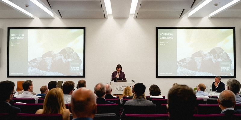 Rachel Reeves MP stands at a podium on a stage to address guests at Northern Gritstone&#039;s AGM.