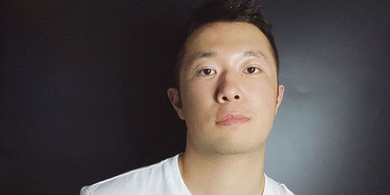 headshot of man looking at camera with black background