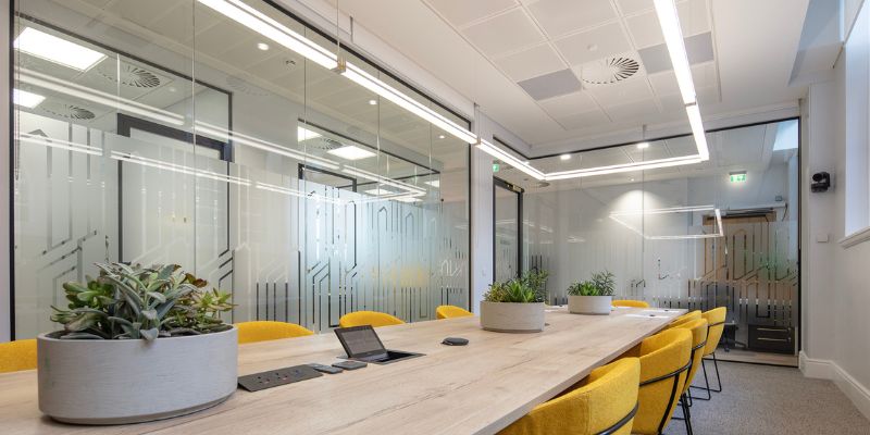 Leeds Institute of Textiles and Colour boardroom, featuring a long wooden table and yellow chairs.