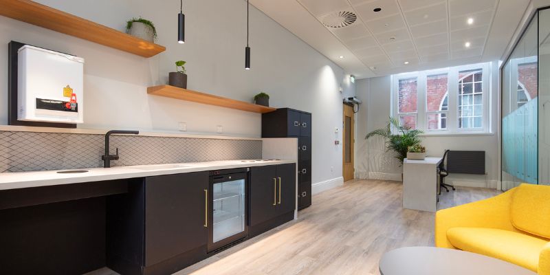 Leeds Institute of Textiles and Colour reception area and kitchen, featuring kitchen units, part of the seating area and the reception desk.