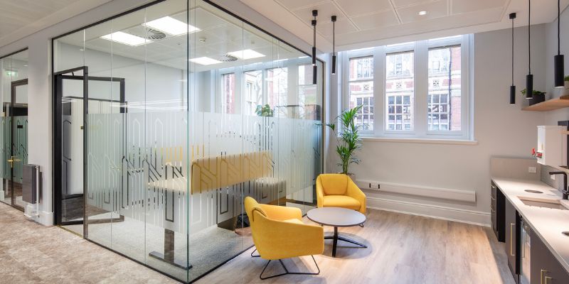 Leeds Institute of Textiles and Colour office, reception area and kitchen, featuring a seating area, glass pannelled offices and kitchen units.