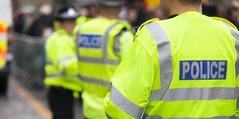 Police officers seen from behind, wearing high visibility jackets