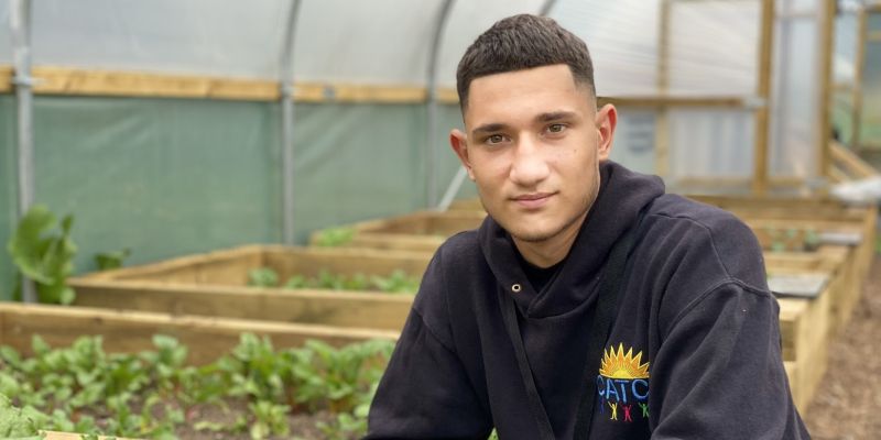 Solomon sitting in a polytunnel