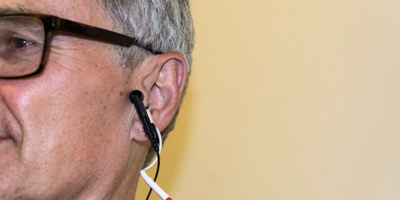 Man receives electrical stimulation via the ear