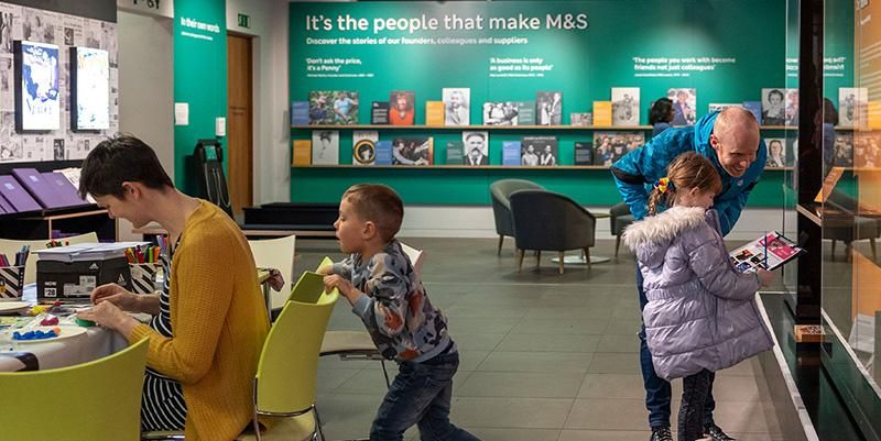 Two children and parents looking at exhibits at the M&S archive