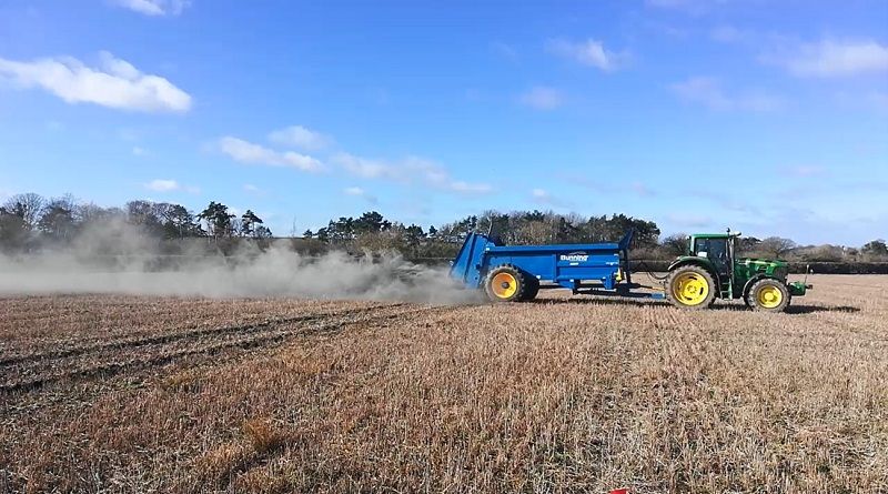 Tractor spreading rock dust in field trial