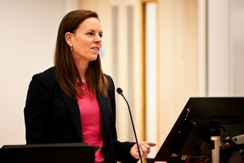 Megan Greene standing in front of a microphone giving her speech