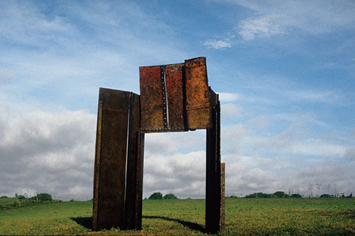 Lenton Cover, a large industrial-looking irregular shape made out of steel from a scrap yard, standing in a field.