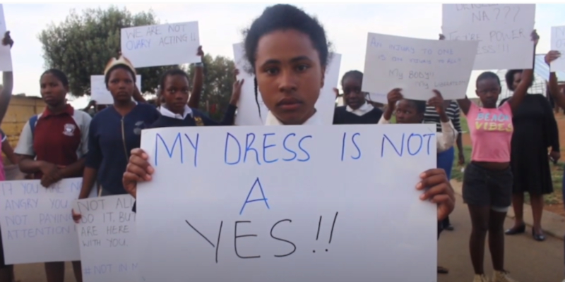 African girl hold up sign saying My Dress Is Not A Yes.