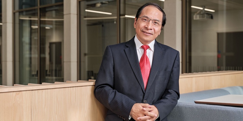 Deputy Vice-Chancellor, Hai Sui Yu, stood inside a university building, smiling.