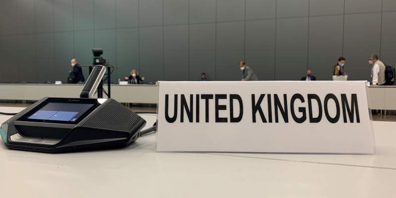 A view of a microphone and United Kingdom plaque from the desk of a negotiator