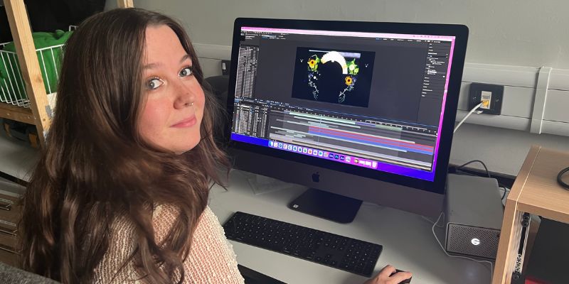 Hannah Guy sits at a computer working on software to create a light installation.