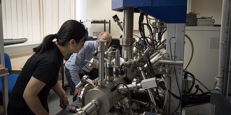 Image shows Dr Sunjie Ye and Professor Stephen Evans at a machine that analyses gold particle.
