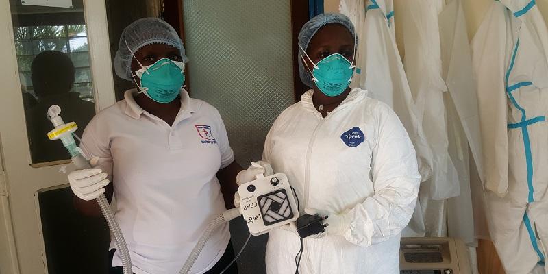 Staff holding a prototype CPAP machine