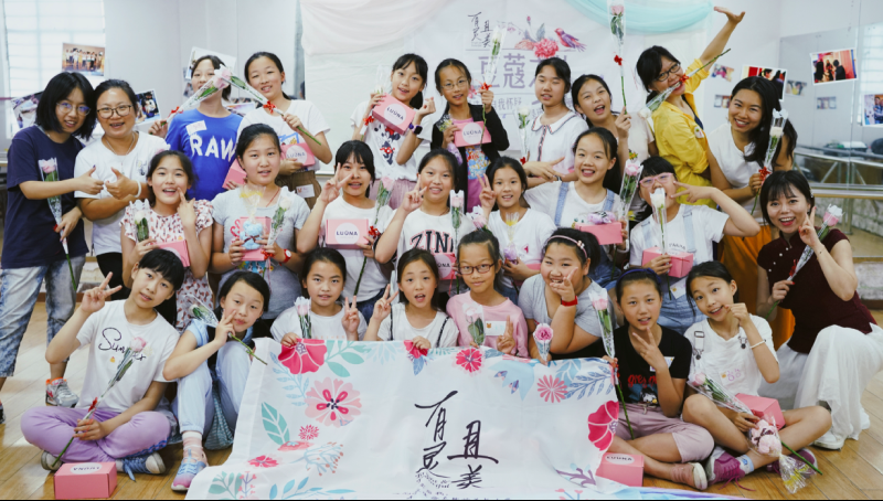 A group of students in Asia holding LUUNA products and roses.