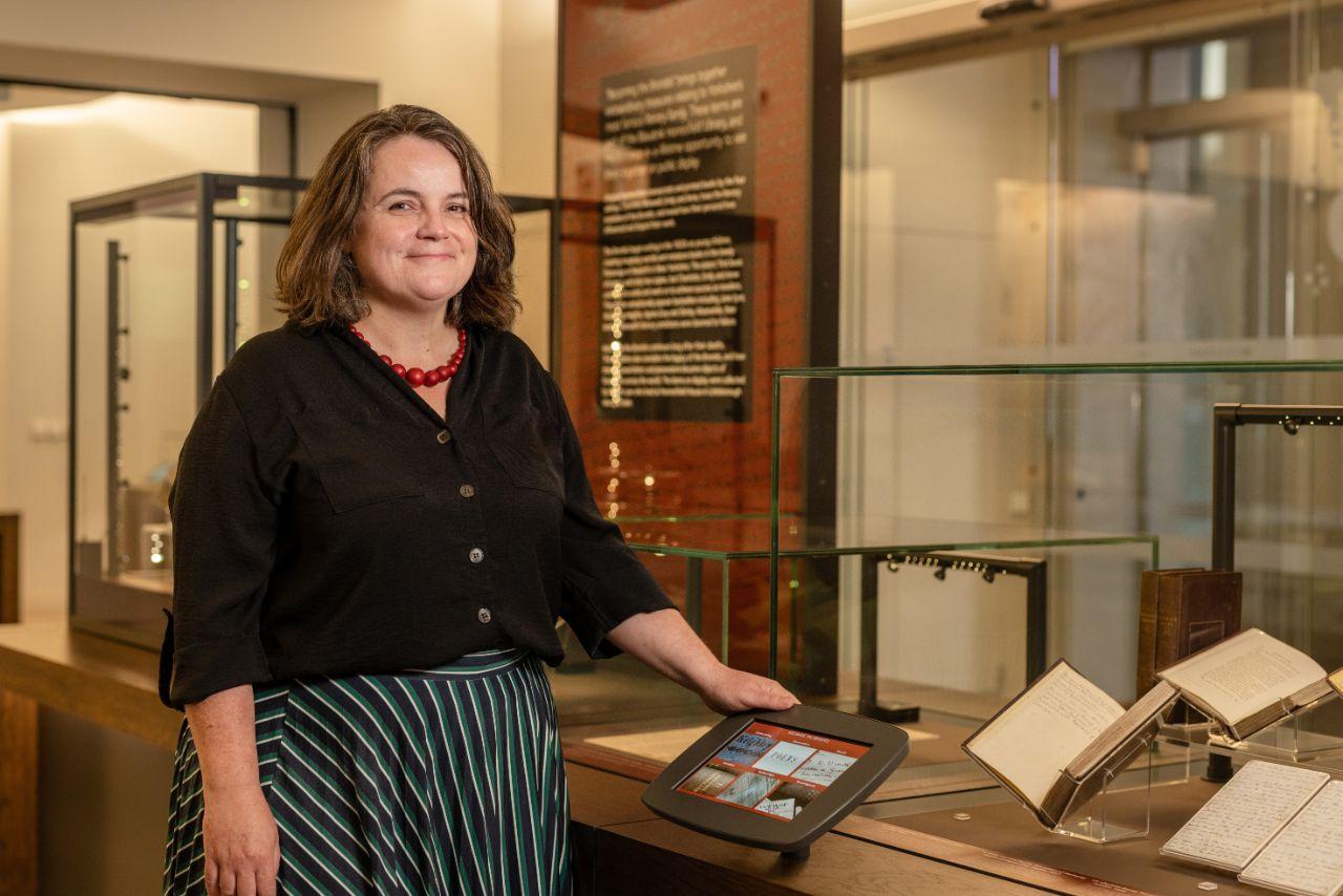 Sarah Prescott, Literary Archivist at the University of Leeds, who was one of the curators of Becoming the Brontës, with the exhibition in the Treasures of the Brotherton Gallery. First editions of major Brontë works in the background.