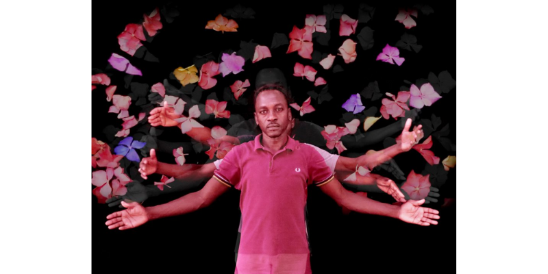 Three men stand behind eachother against a black background with their arms held out at different angles. They are surrounded by colourful flowers
