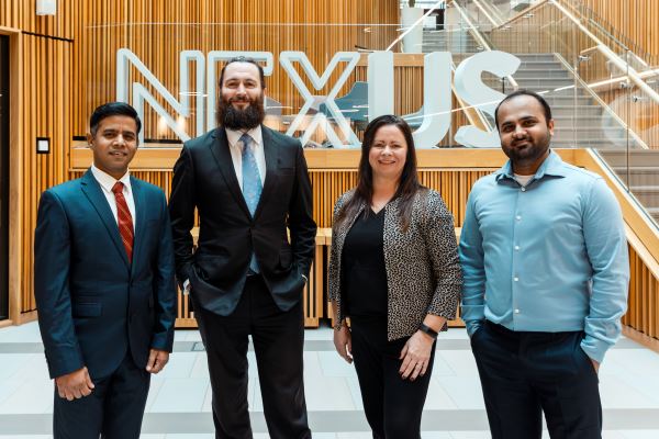 A group of four people stood behind the Nexus logo