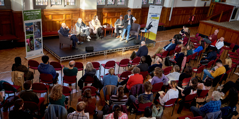 View of the event from the Great Hall balcony showing speakers on stage and members of the audience facing them