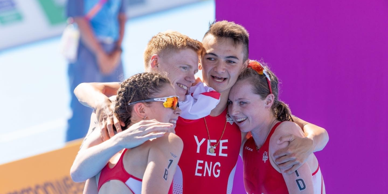 Sam (second from left) celebrates on the finish line with his triathlon team mates