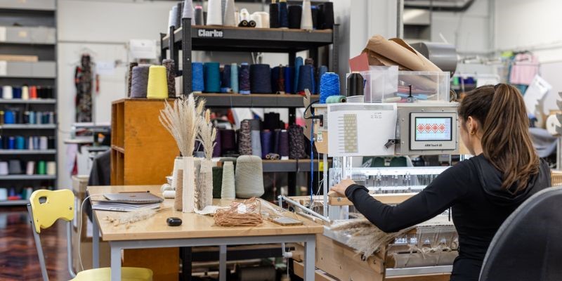 A student using the knit machines in the Knit and Weave Studio, School of Design.