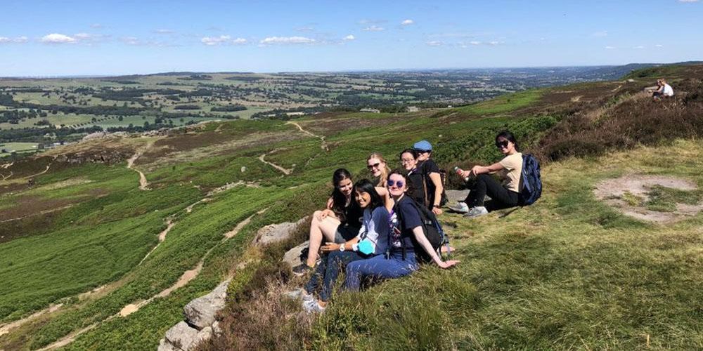 A group of Leeds International Summer School students sitting on Ilkley Moor