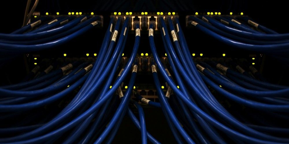 Numerous blue wires feed into a lit-up switchboard.