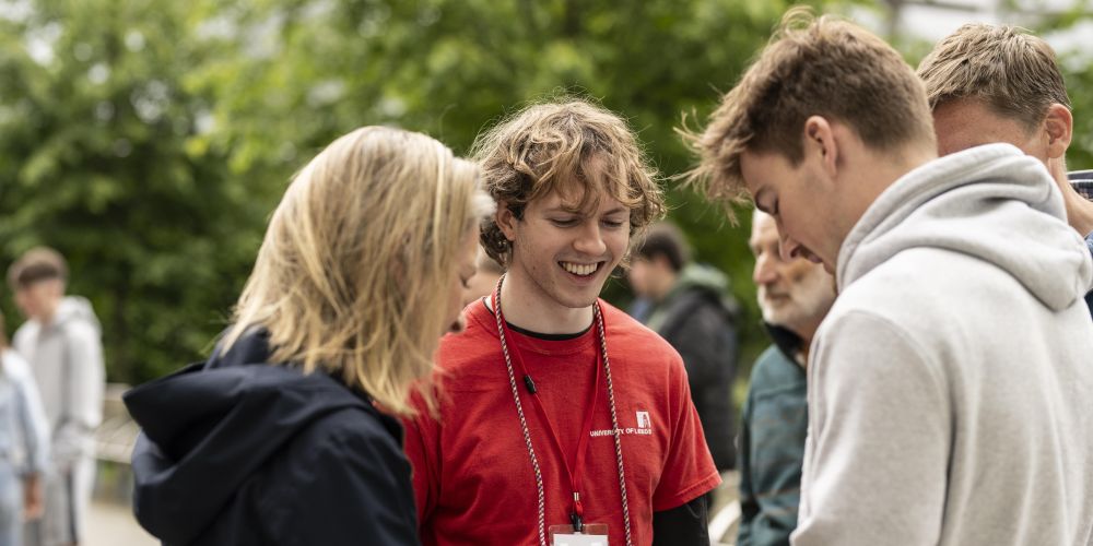 A student ambassador speaking to two people on an open day