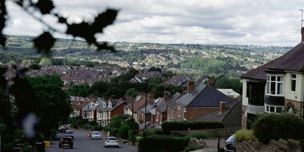 Looking down a hill at a residential street in Sheffield with houses going into the distance.