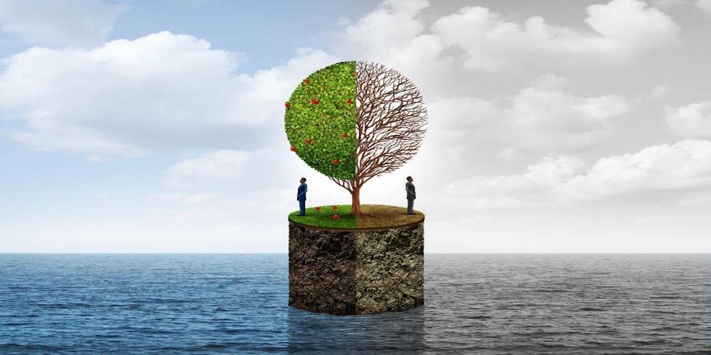 A seascape split vertically down the middle, with a small island growing a tree. The left side is colourful with leaves and fruit on the tree and blue sky and sea; the right side is grey and the tree is dead.