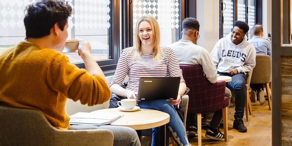 Students sat at tables in a cafe chatting