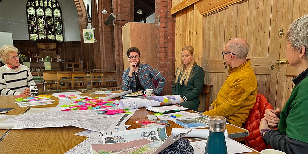 A group around a table of paperwork for community-led urban planning in York.