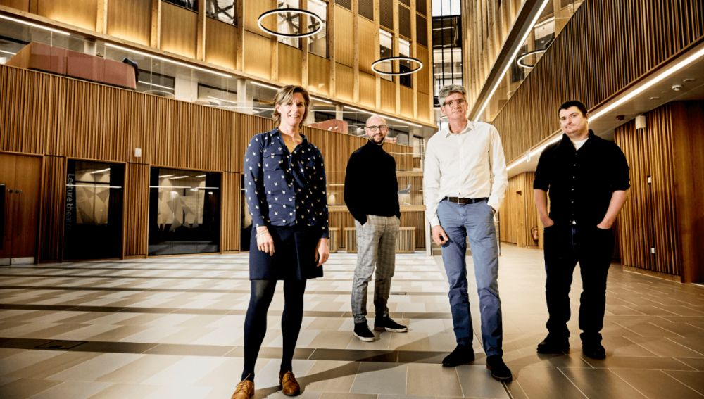 Image of four members of staff of start-up Vet-AI, stood in the Nexus atrium looking into camera.