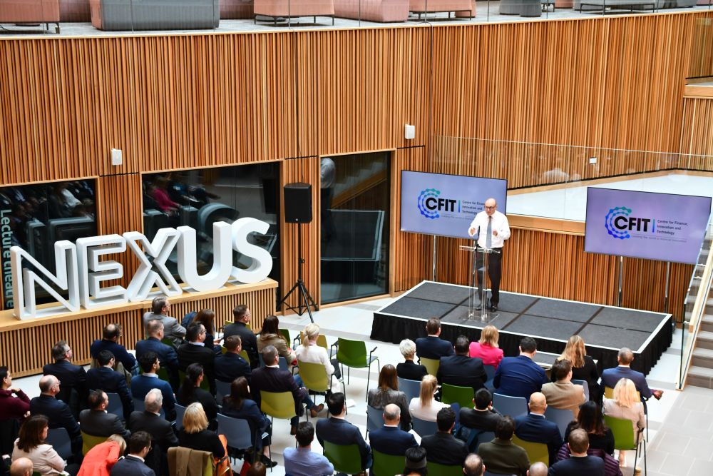 Guests seated in rows listen to speeches at the launch event of CFIT, in the atrium of Nexus