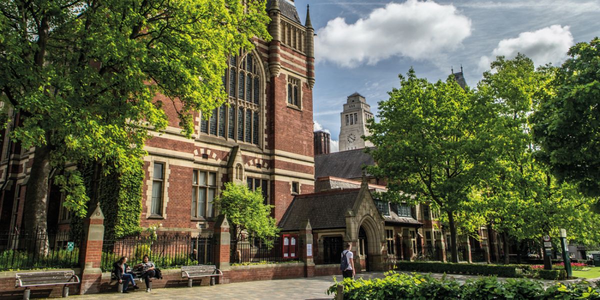 The front of the Great Hall on campus on a sunny day surrounded by green trees