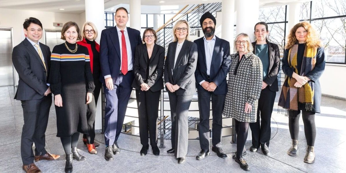 A group of delegates from University of Leeds, including Professor Shearer West, stand together, facing the camera.
