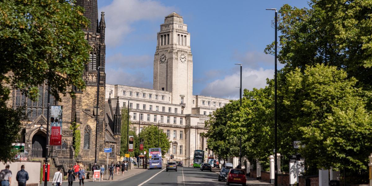 Woodhouse Lane and the Parkinson Building in the sunshine, with students walking towards campus.