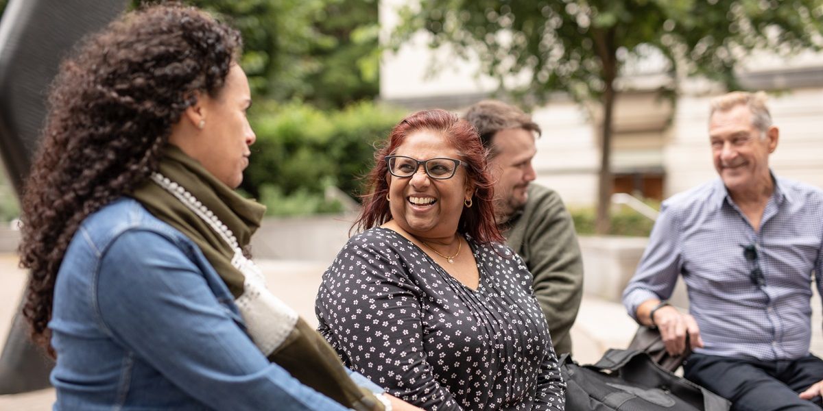 Four mature students sat outside on campus chatting