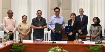 A delegation from the universities of Leeds and Delhi present a signing book.
