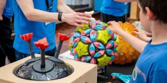 Child discovering a textured ball at Be Curious.