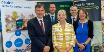 Representatives of the universities of Leeds and Huddersfield alongside Mayor Tracy Brabin at a conference stand.
