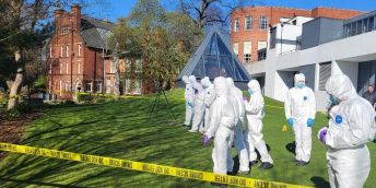 A group of schoolchildren from Wakefield comb a mocked up crime scene on the University of Leeds campus to learn about what forensics officers look for.