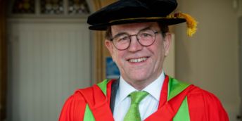 Roger Gair smiling in graduation robe