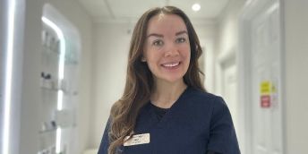 Jade stands in her clinic wearing a medical uniform.