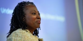 Professor Lisa-Dionne Morris speaking at her inaugural lecture with her slides behind her on the board.