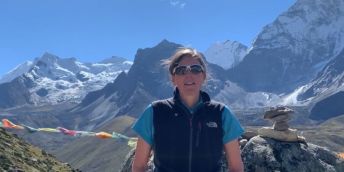 Dr Shaunna Burke standing in front of large mountains
