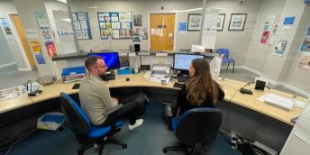The Business Manager and the Patient Navigator at The Light Surgery in Leeds sit on reception and chat to each other.
