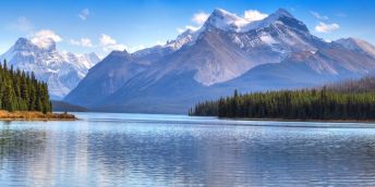 A lake surrounded by trees and mountains