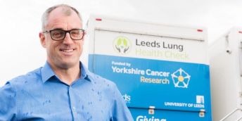 Professor Matthew Callister smiles in front of a Leeds Lung Health Check van. The van says 'Funded by Yorkshire Cancer Research' and has the University of Leeds logo on the right.