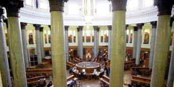 The library in the parkinson building, with studetns working at desks surrounded by books.